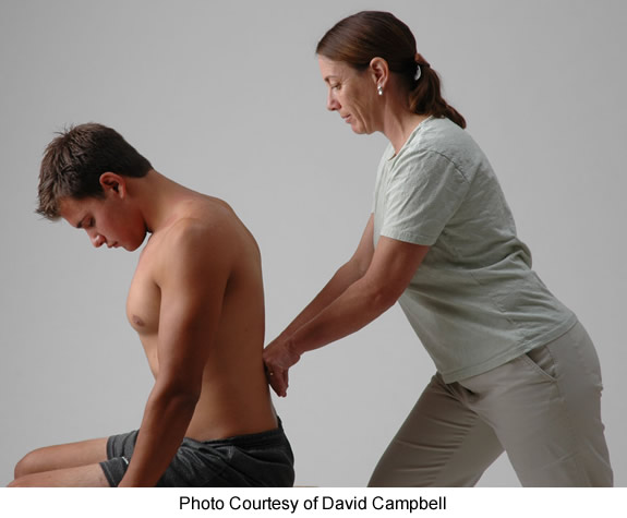 Rolfing® session Rolfing® practitioner working on patient's lower back